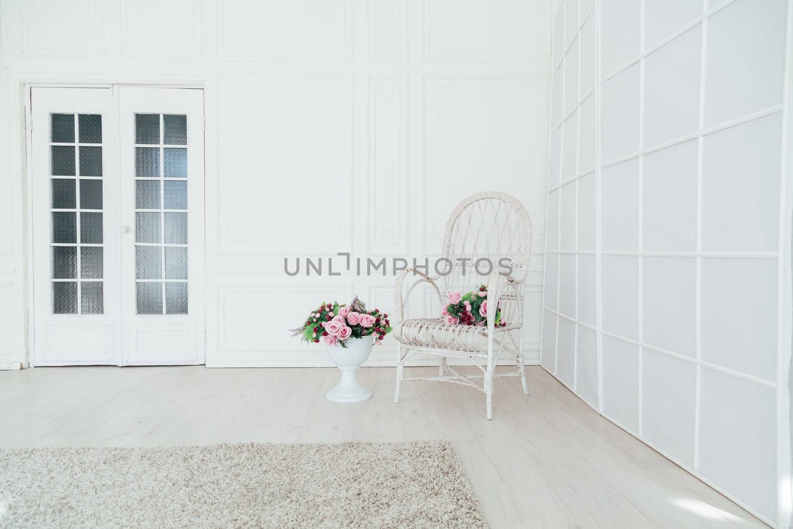 white vintage chair with flowers in the interior of the white room by Simakov