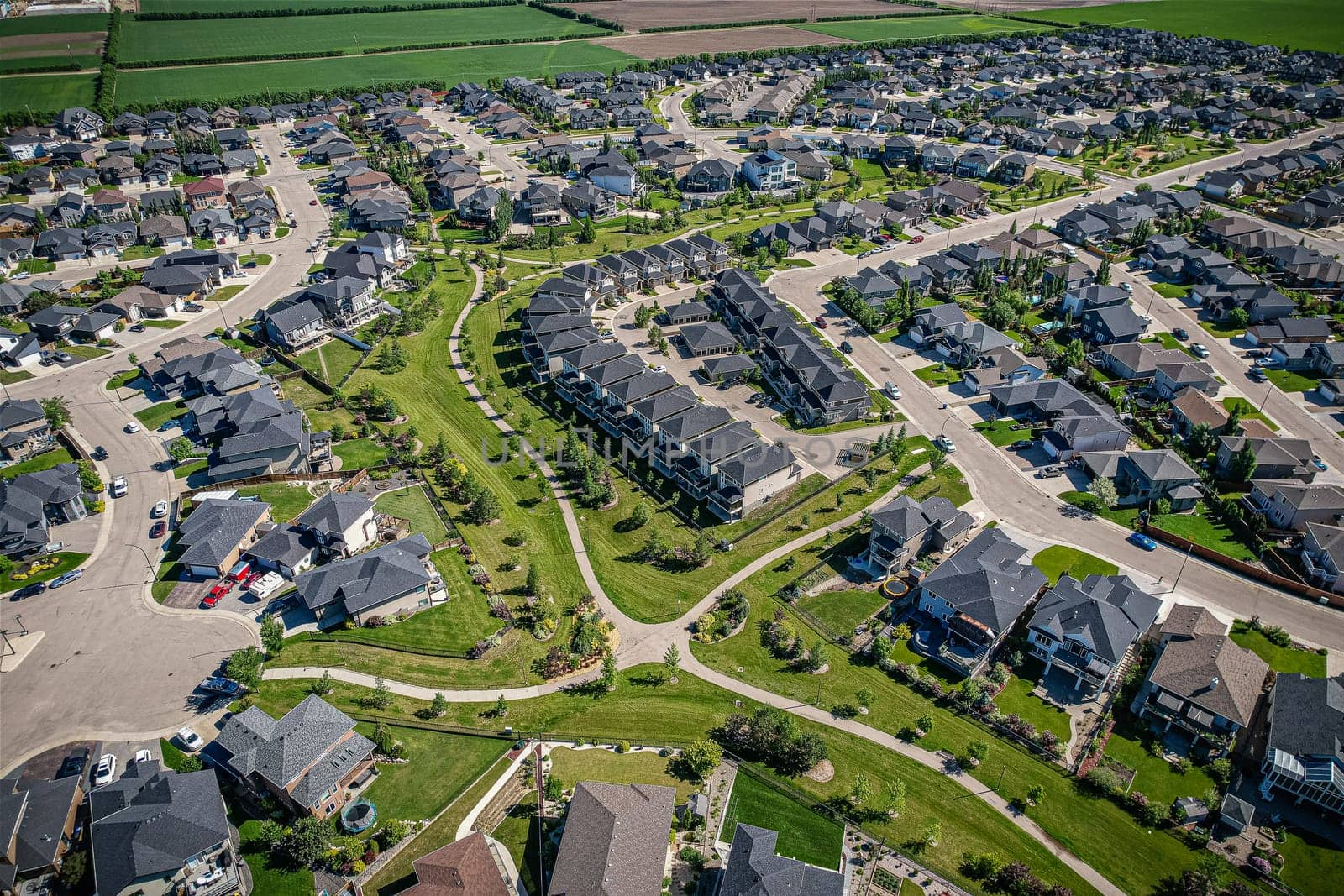 Elevated panorama of Willowgrove, showcasing the neighborhood's modern aesthetics intertwined with pockets of lush green, epitomizing Saskatoon's suburban beauty