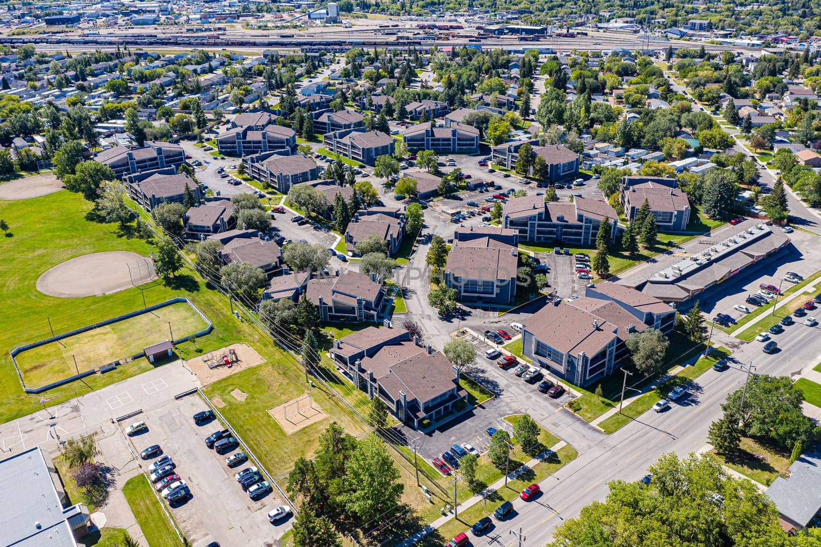 Explore the lush Forest Grove neighborhood in Saskatoon from an aerial perspective. This drone image captures the area's verdant charm, peaceful streets, and community warmth, under the vast Saskatchewan sky.