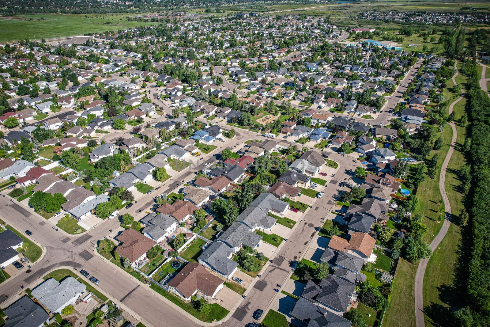 Aerial journey over Silverspring in Saskatoon, revealing a harmonious blend of suburban life, green expanses, and the distinct charm of Saskatchewan's landscapes.