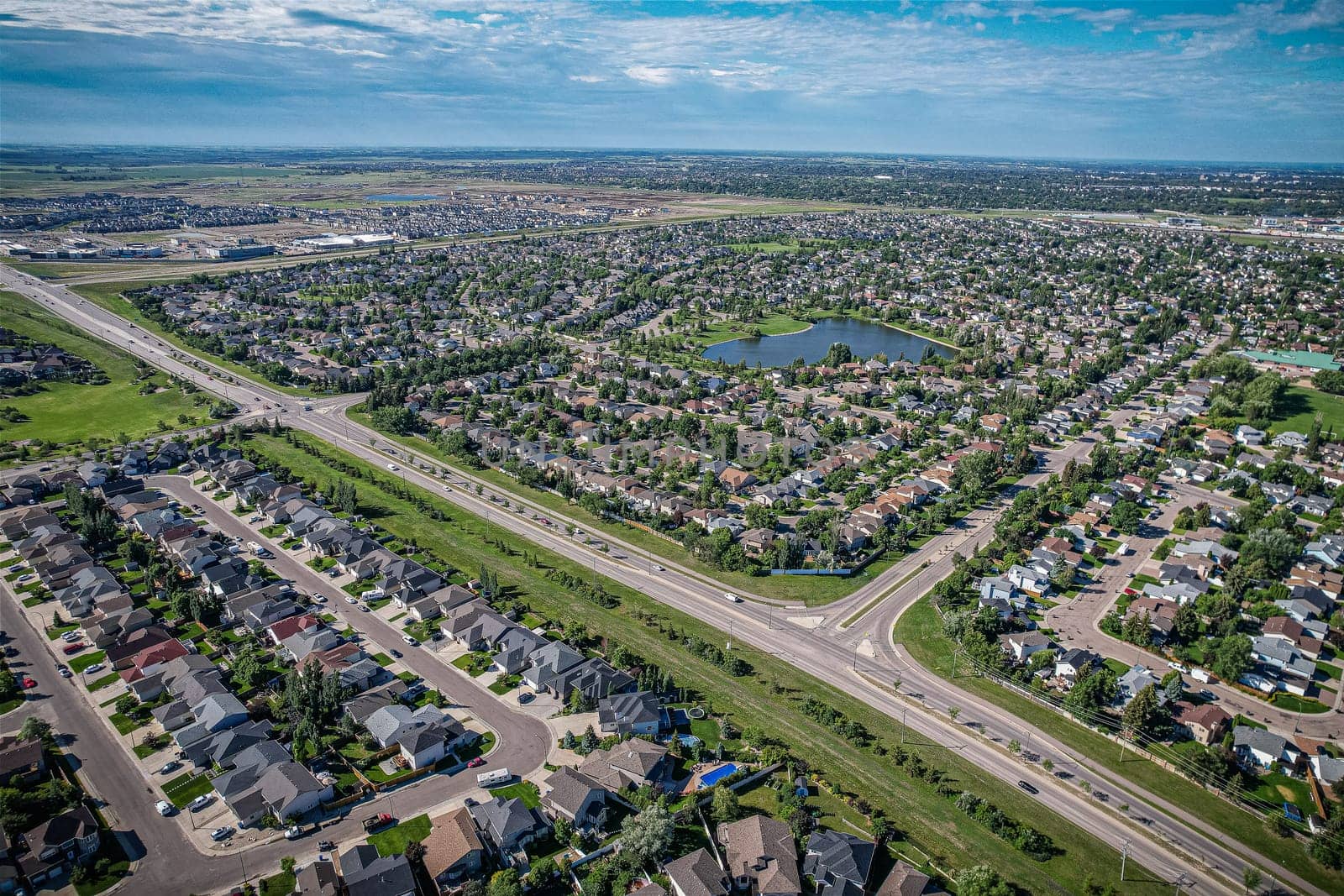 Elevated panorama of Willowgrove, showcasing the neighborhood's modern aesthetics intertwined with pockets of lush green, epitomizing Saskatoon's suburban beauty