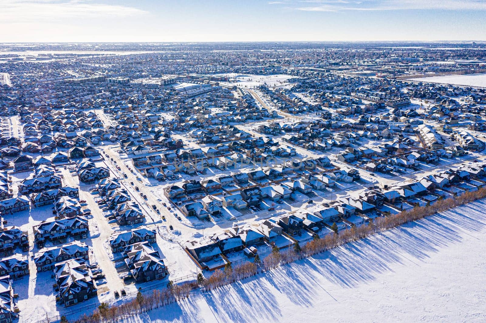 Aerial image of Willowgrove, Saskatoon, SK, showcasing its modern homes, intricate pathways, and lush parks. A neighborhood echoing family-centric living. Ideal for urban planning and real estate.