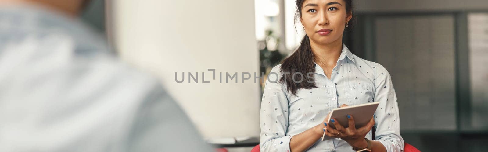 HR manager holding digital tablet and looking on job candidate during interview. High quality photo