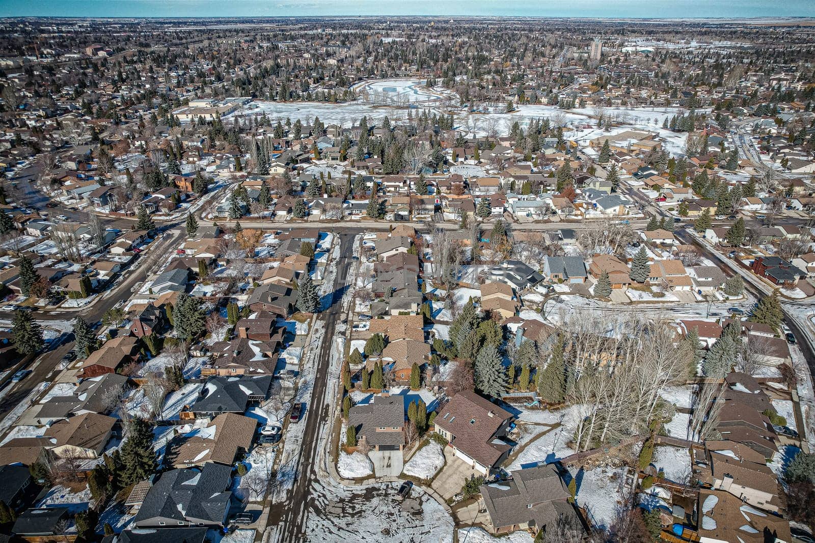 Soaring over Lakeview in Saskatoon, this bird's-eye capture magnifies the neighborhood's tranquil waters, verdant parks, and the serene rhythm of Saskatchewan living