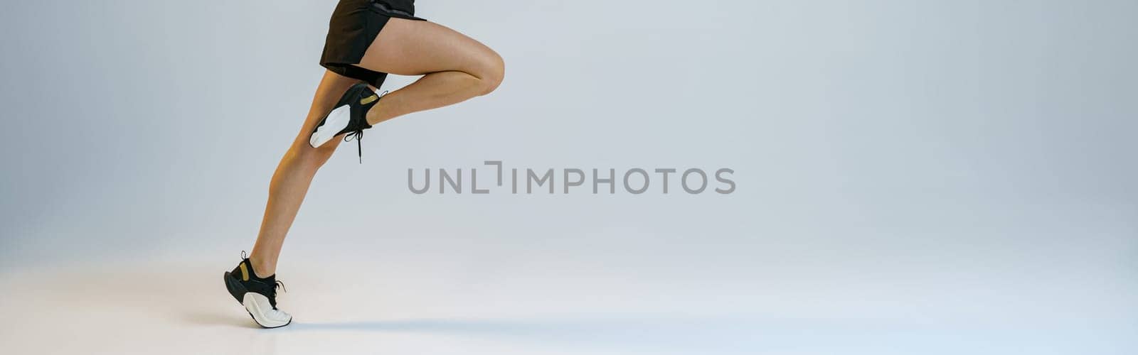Athletic active woman running on studio background. Dynamic movement