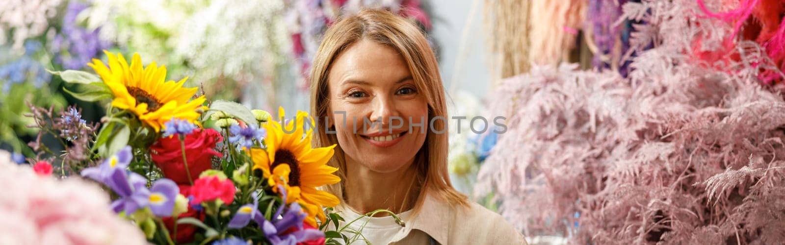 Female decorator creating beautiful bouquet at table. Lifestyle flower shop
