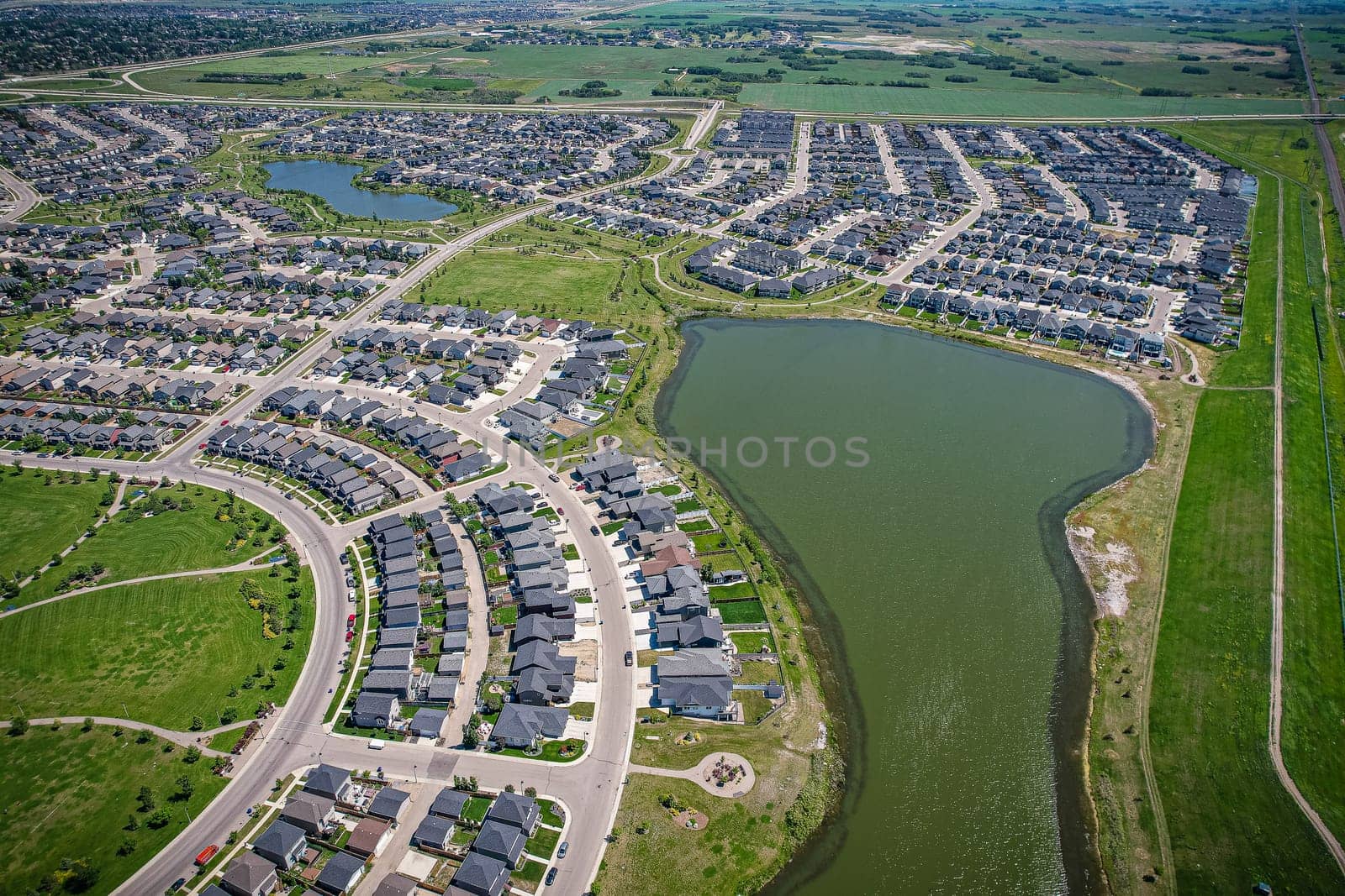 Captivating aerial shot of Stonebridge in Saskatoon, highlighting the harmonious blend of modern architecture and Saskatchewan's verdant surroundings.
