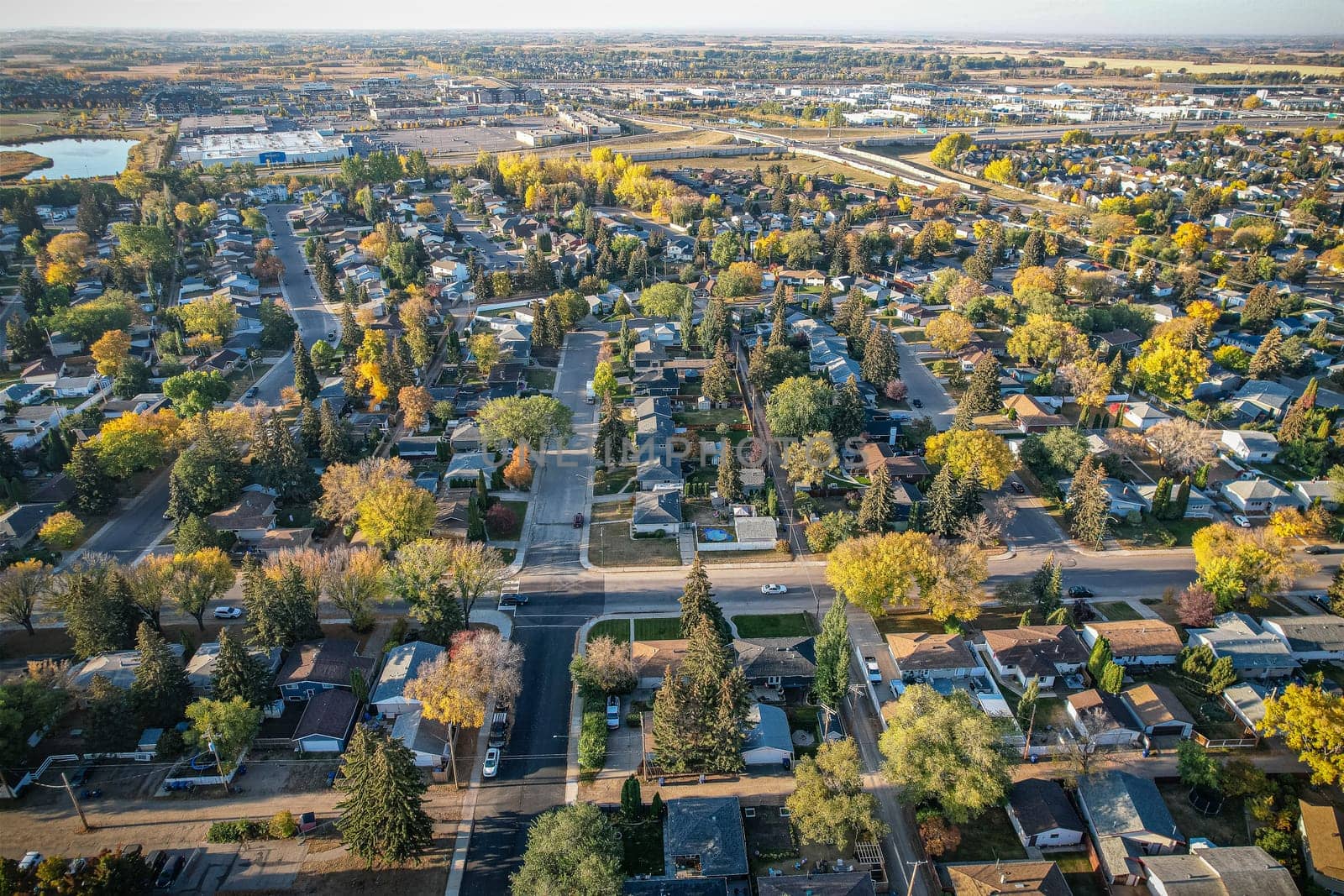 Soaring over Lakeview in Saskatoon, this bird's-eye capture magnifies the neighborhood's tranquil waters, verdant parks, and the serene rhythm of Saskatchewan living