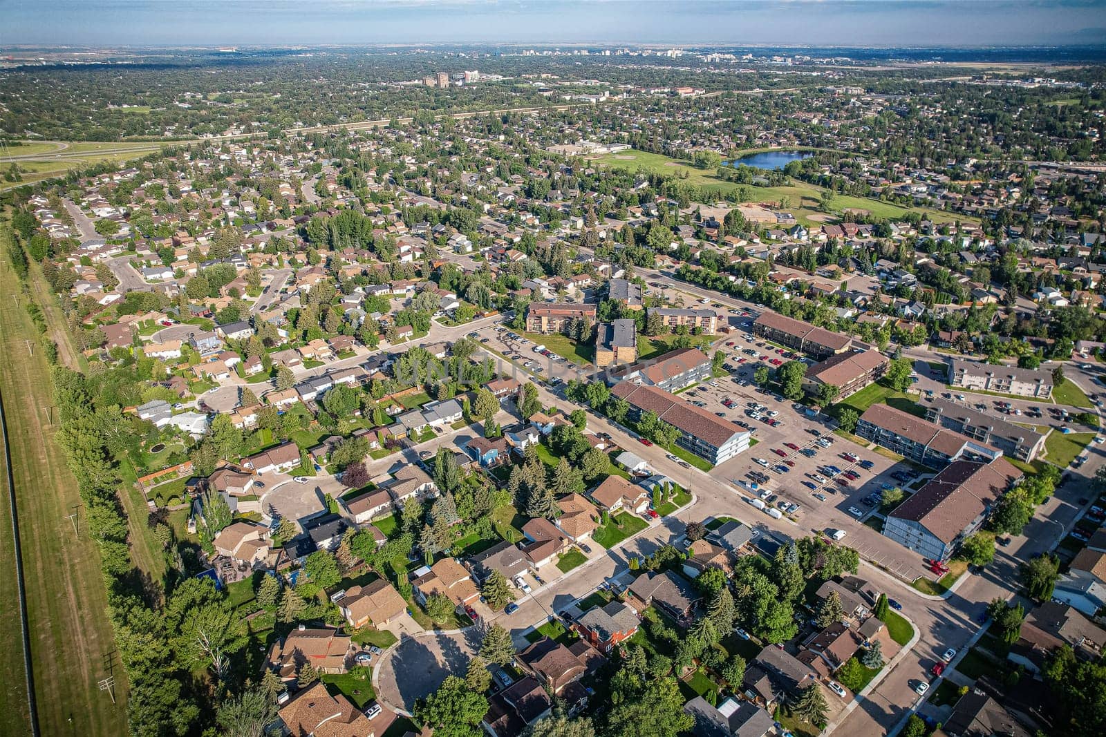 Soaring over Lakeview in Saskatoon, this bird's-eye capture magnifies the neighborhood's tranquil waters, verdant parks, and the serene rhythm of Saskatchewan living
