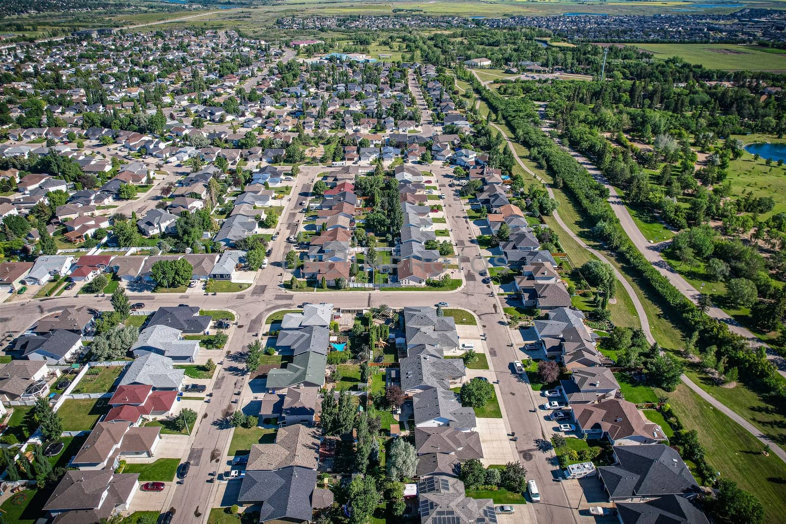Aerial journey over Silverspring in Saskatoon, revealing a harmonious blend of suburban life, green expanses, and the distinct charm of Saskatchewan's landscapes.