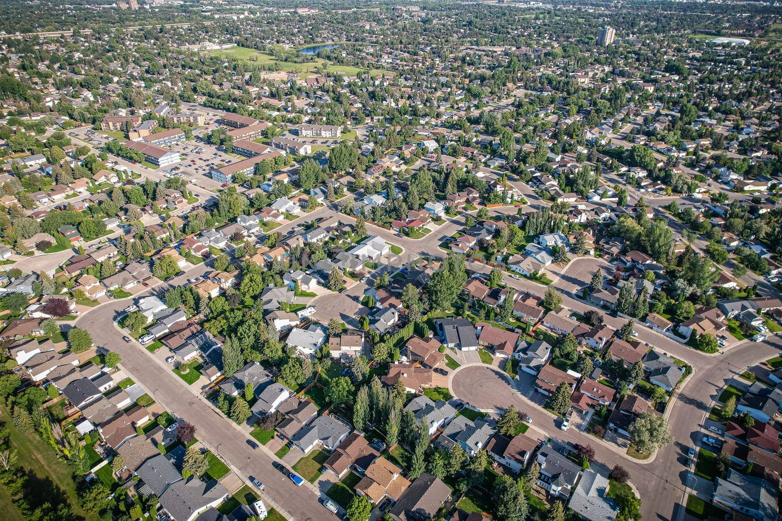 Soaring over Lakeview in Saskatoon, this bird's-eye capture magnifies the neighborhood's tranquil waters, verdant parks, and the serene rhythm of Saskatchewan living