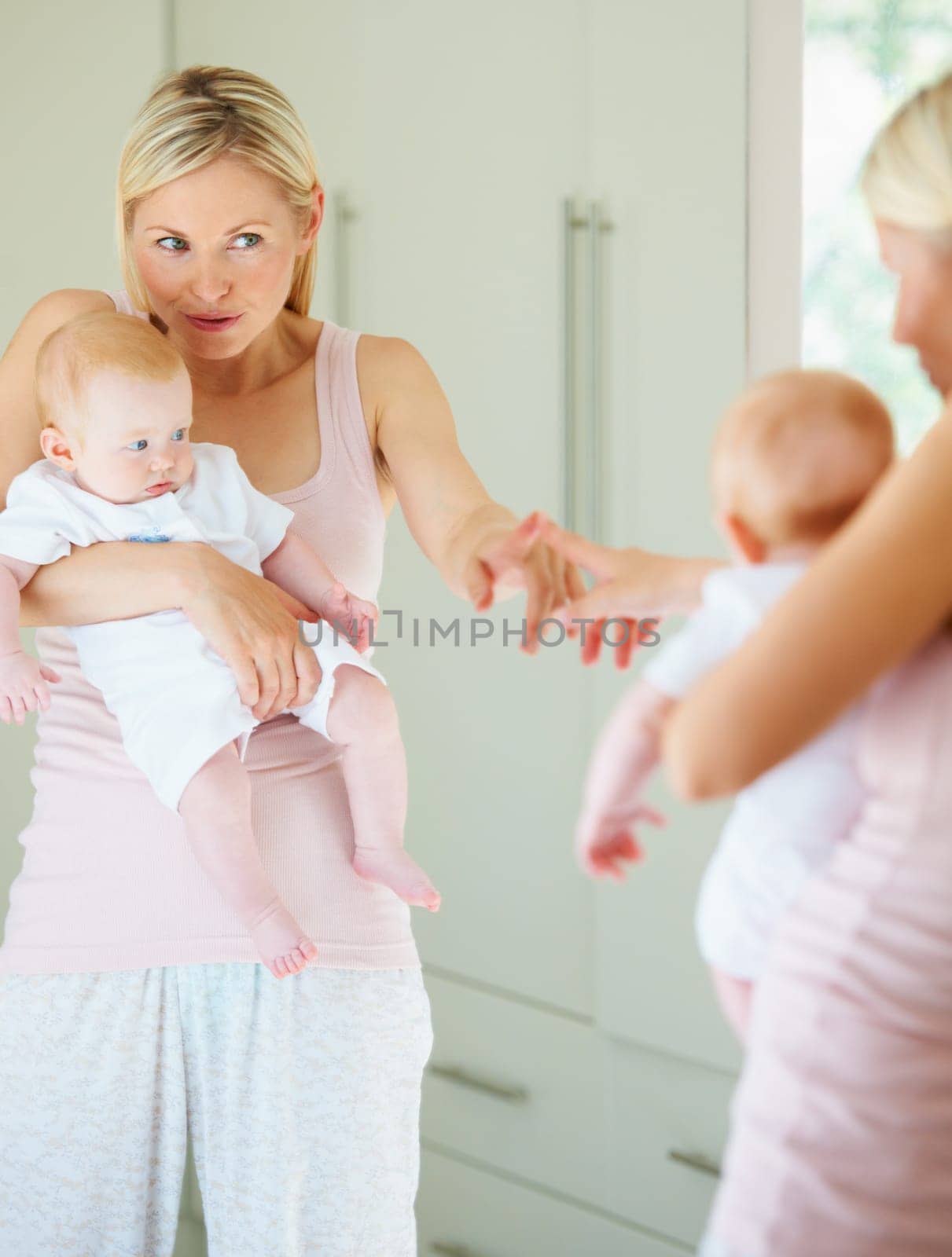 Mother, baby and love in mirror, care and hug in reflection, home and learning for development. Mom, child and bonding or embrace, security and family or play, motherhood and creative education.