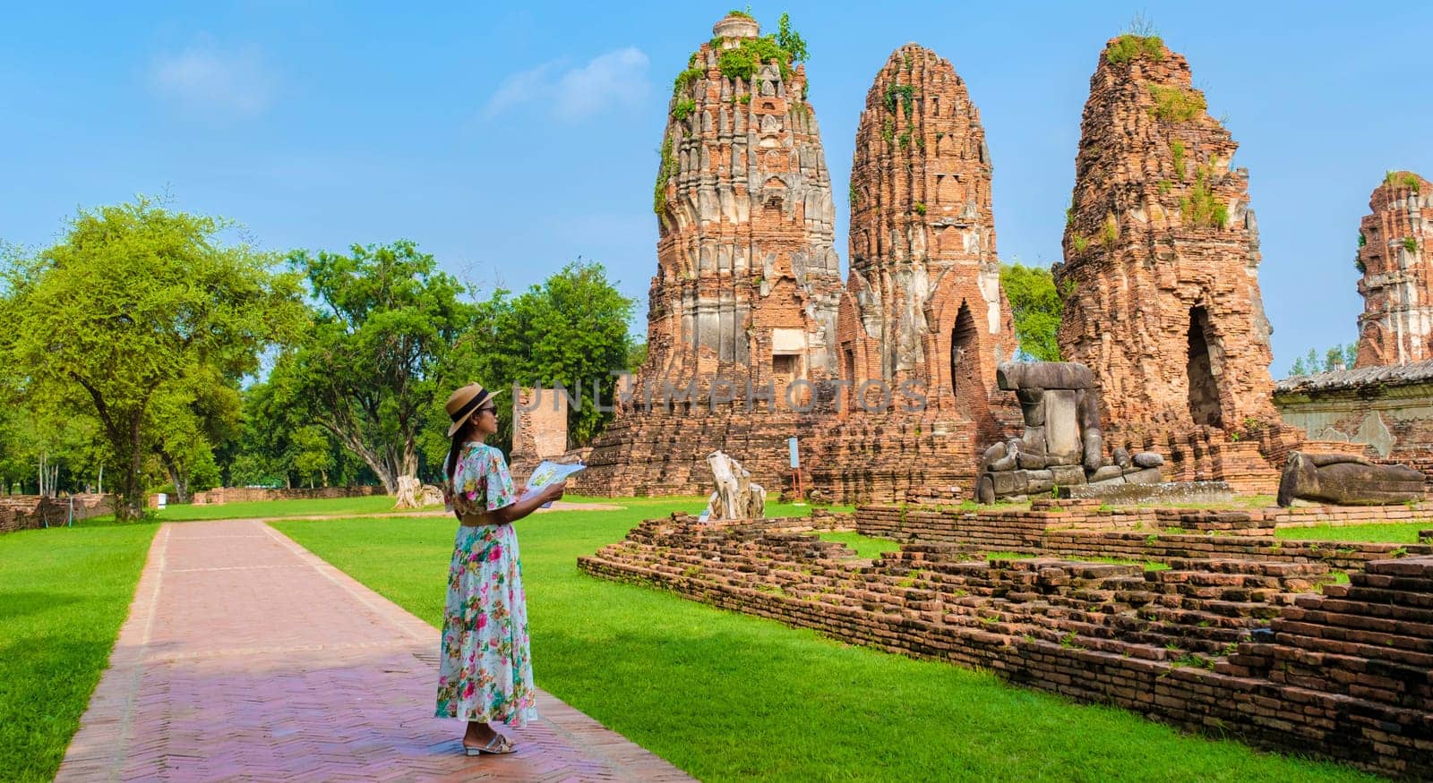 Ayutthaya, Thailand at Wat Mahathat, women with a hat and tourist map visiting Ayutthaya Thailand. Tourists with a map of Thailand looking at an old temple