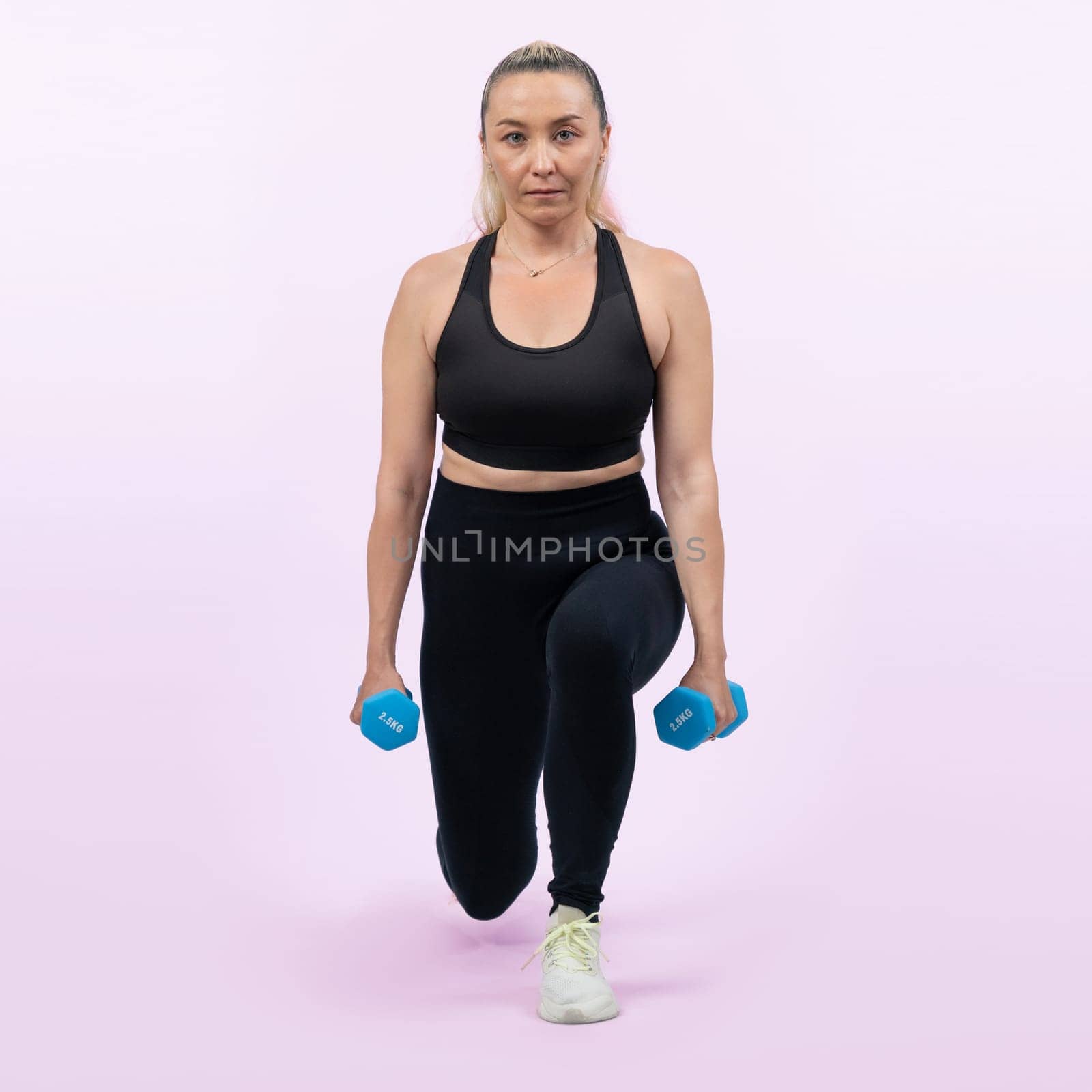 Full body length shot active and sporty senior woman lifting dumbbell. Clout by biancoblue