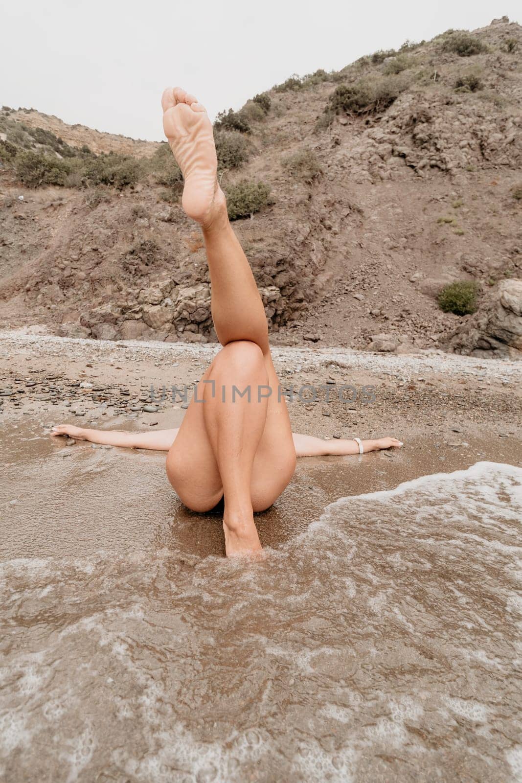 Woman summer travel sea. Happy tourist in blue bikini enjoy taking picture outdoors for memories. Woman traveler posing on the beach surrounded by volcanic mountains, sharing travel adventure journey by panophotograph