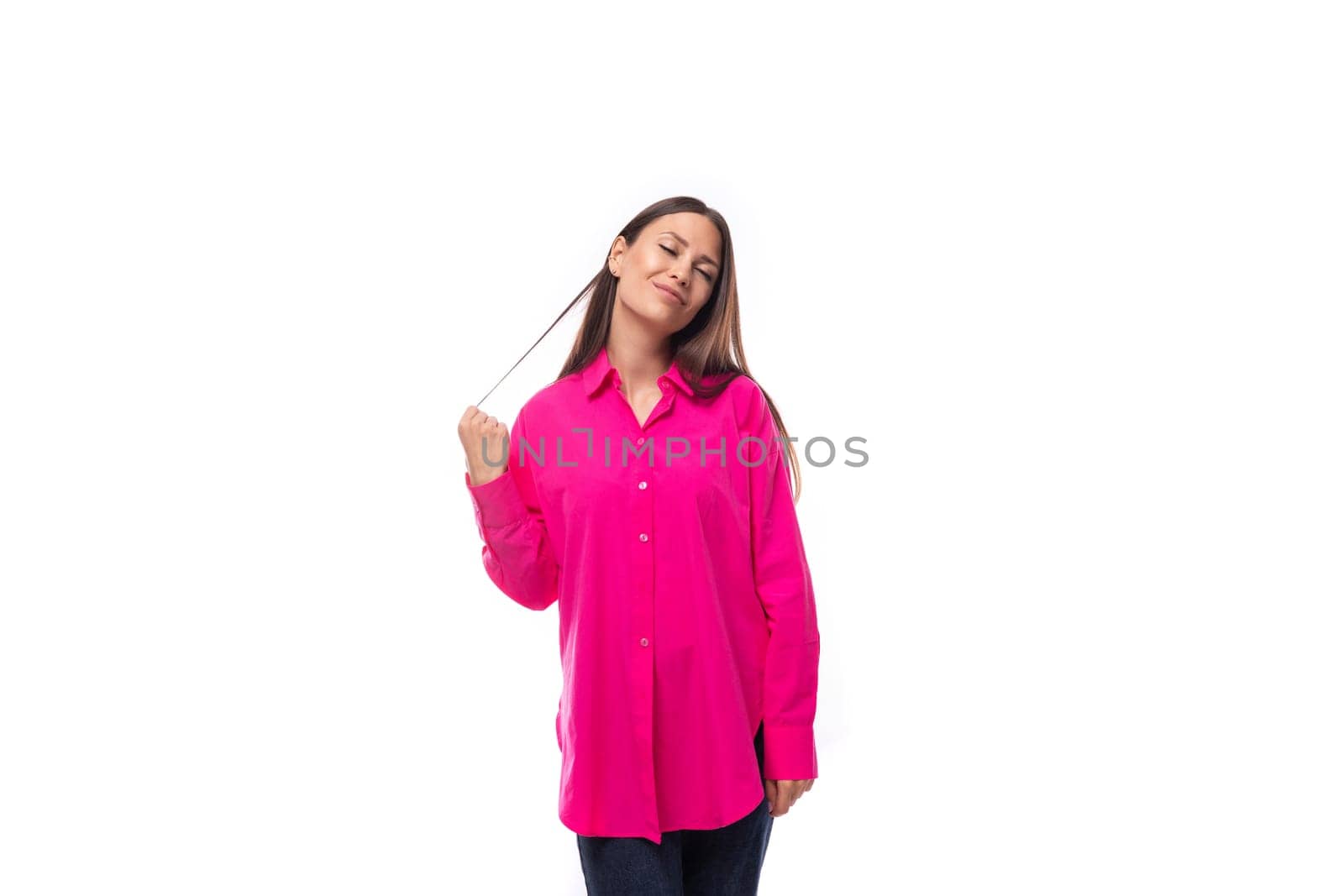 portrait of a dreamy young lady with black hair in a crimson oversized shirt on a studio white background.