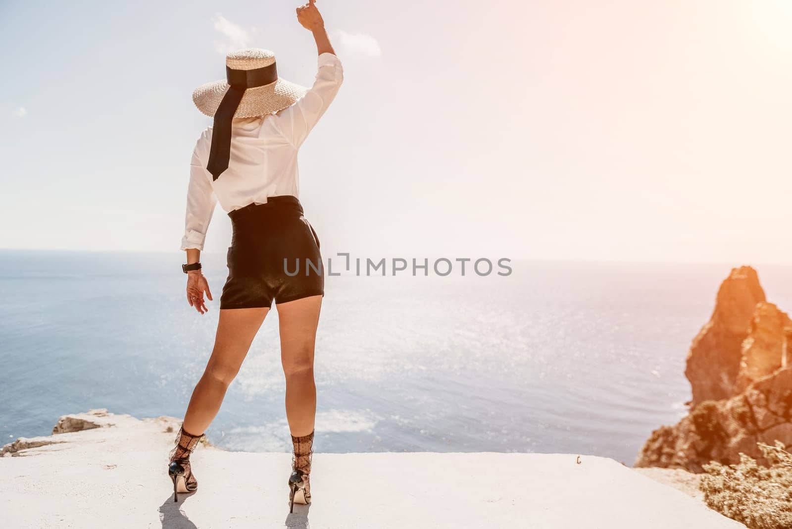 Woman sea hat. Business woman in yellow hat freelancer working over blue sea beach. Girl relieves stress from work. Freelance, digital nomad, travel and holidays concept by panophotograph
