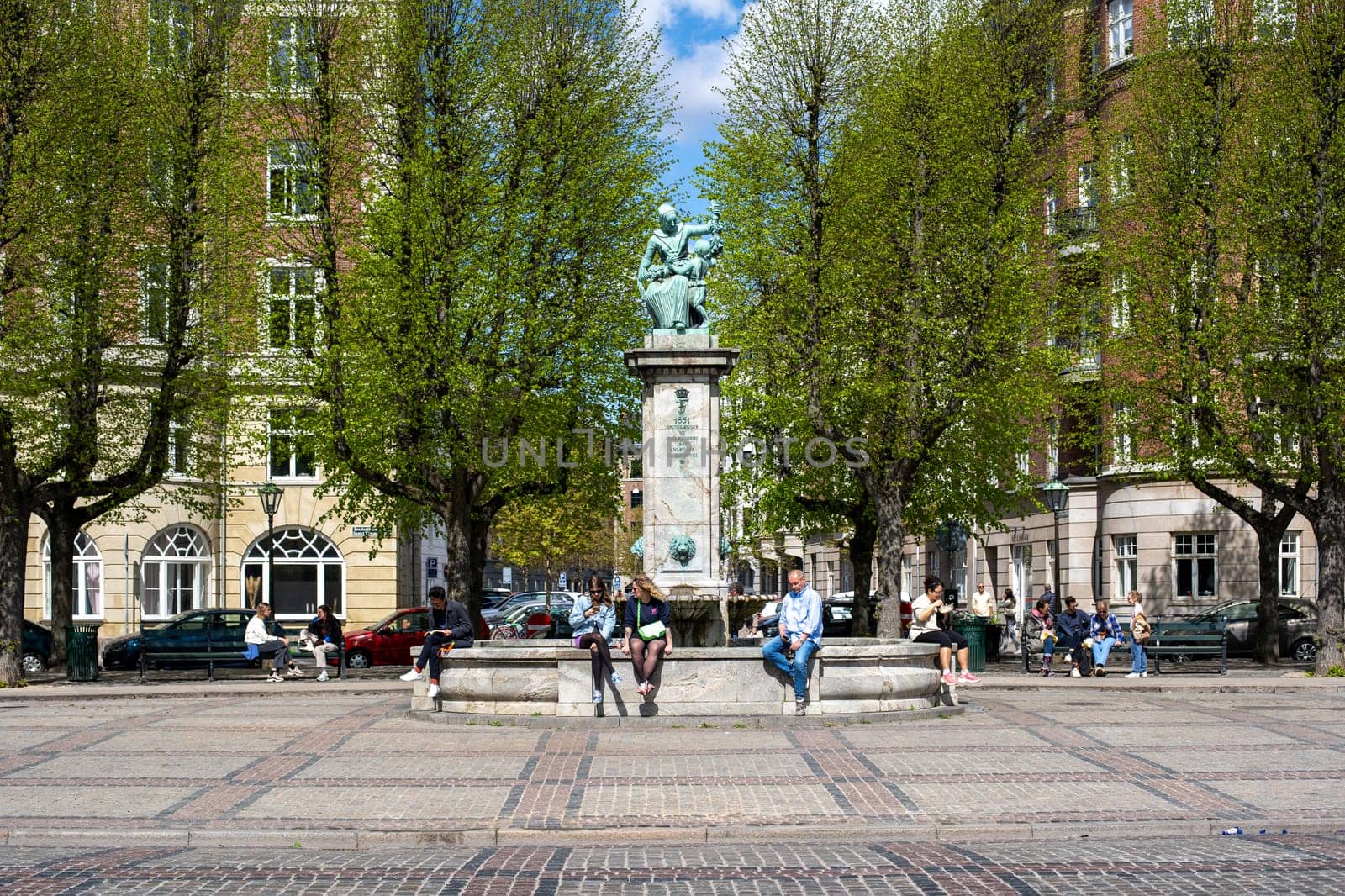 Frederiksberg, Denmark - May 7, 2022: Historic fountain and people on Sankt Thomas Plaza.