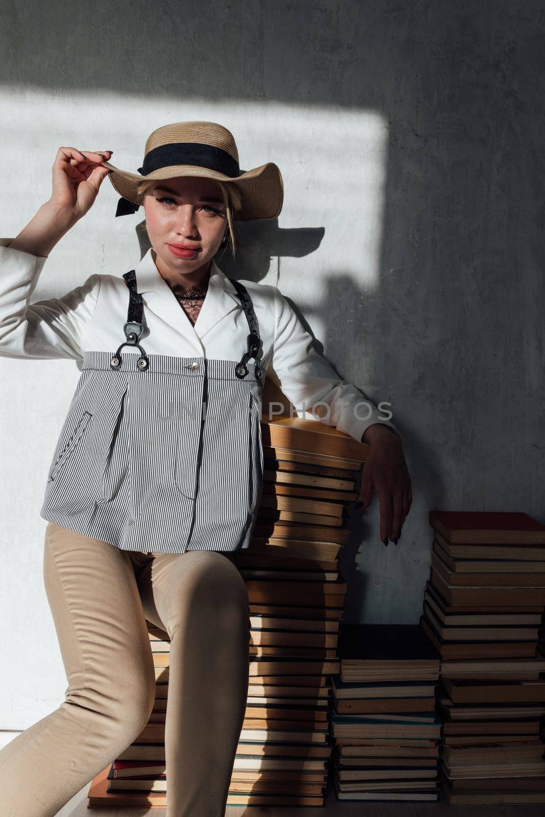 Beautiful woman sitting on books loves to read