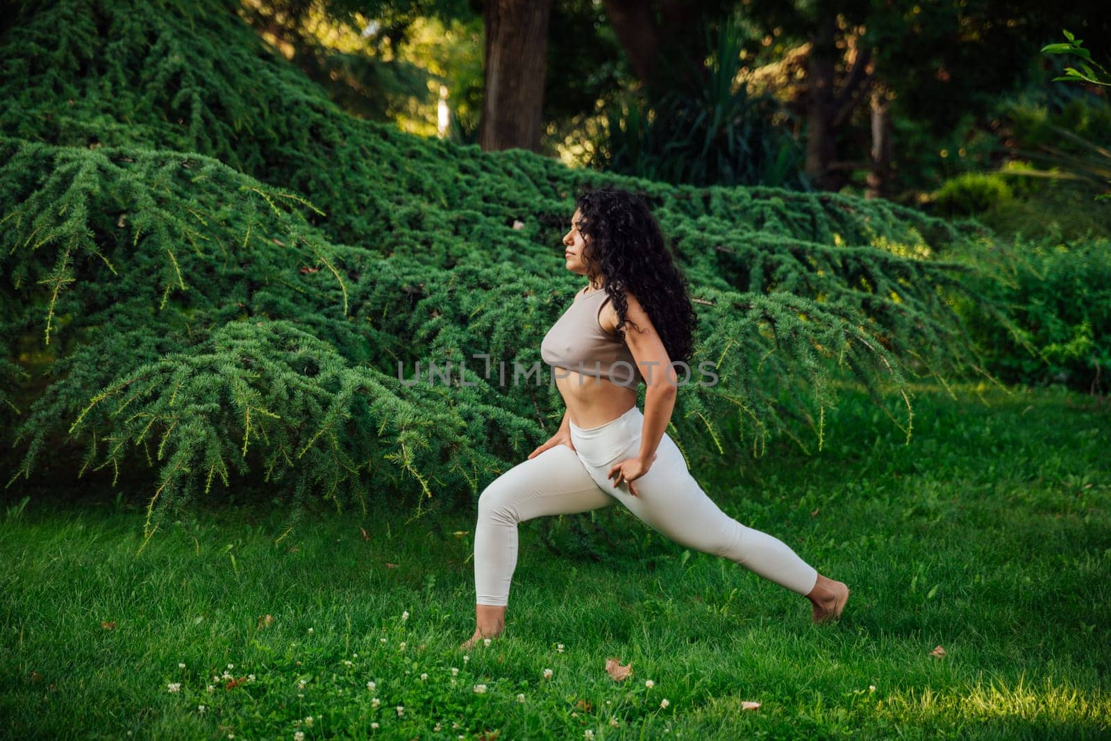 Young asian woman practicing yoga during workout in park