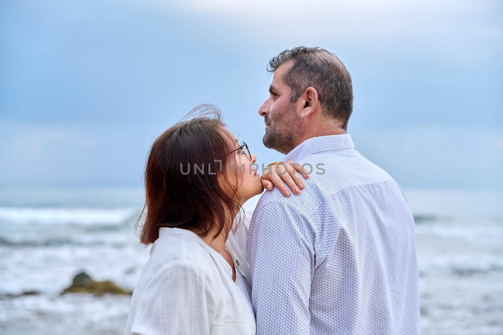Outdoor portrait of mature couple embracing against the background of sea nature. Middle-aged happy romantic man and woman. Relationships, feelings, lifestyle, marriage, people concept