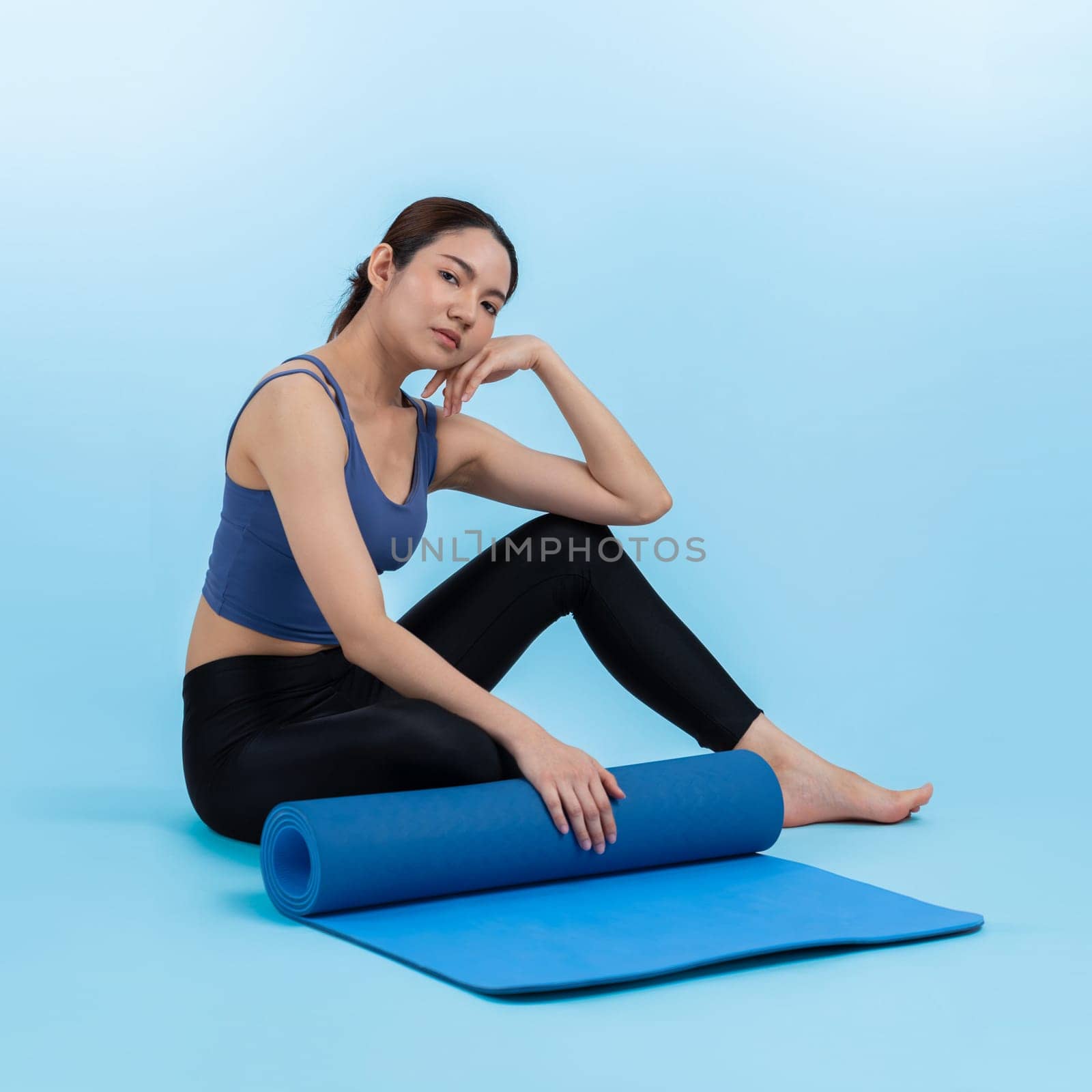 Young attractive asian woman portrait in sportswear with exercising mat. Healthy exercise and workout routine lifestyle concept. Studio shot isolated background. Vigorous