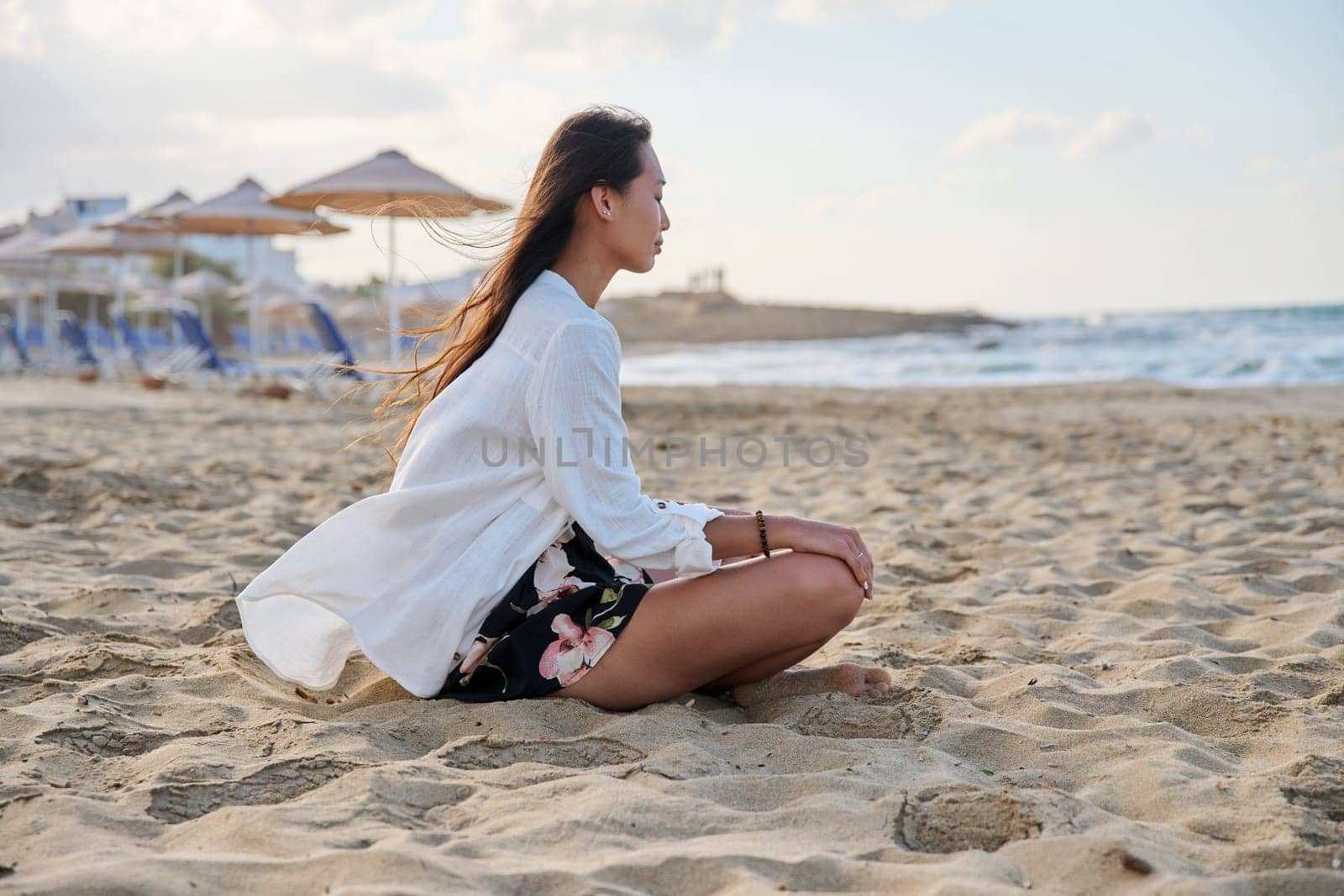 Young relaxed woman sitting in lotus position on beach, morning sea nature by VH-studio