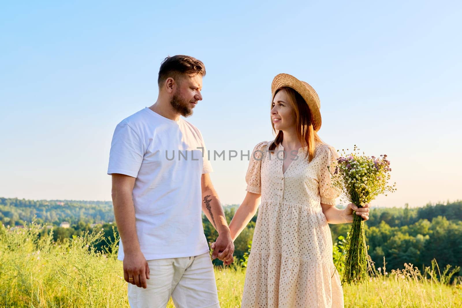 Couple holding hands smiling talking, summer nature blue sky background by VH-studio