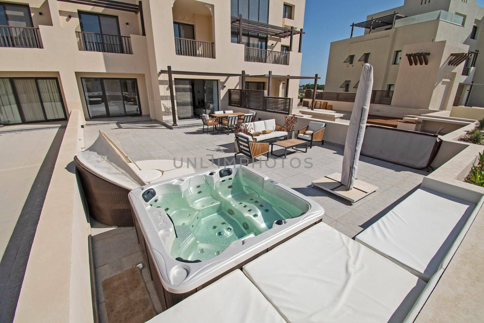 Roof terrace patio furniture at a luxury holiday villa in tropical resort with table and hot tub