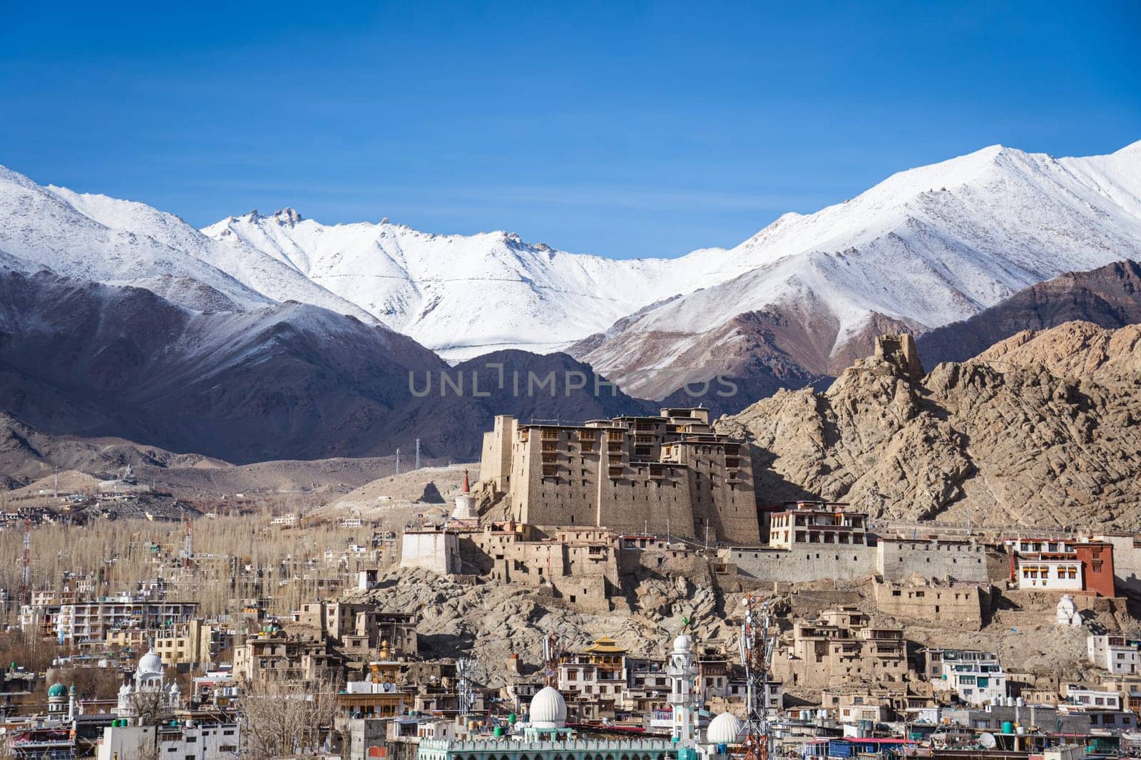 Leh, India - April 02, 2023: View the city with Leh Palace and with snow capped mountains in the background
