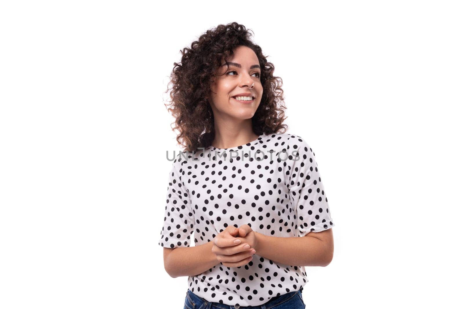 young leader woman with curly hairstyle dressed in summer blouse with polka dot print feels confident by TRMK