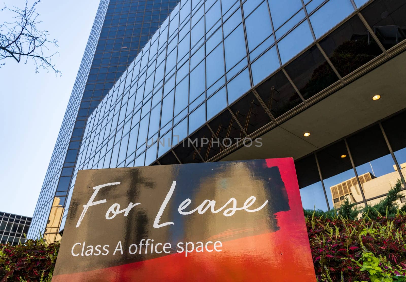 For Lease sign in front of mirrored surface of modern skyscraper office building on Market St in downtown St Louis in Missouri