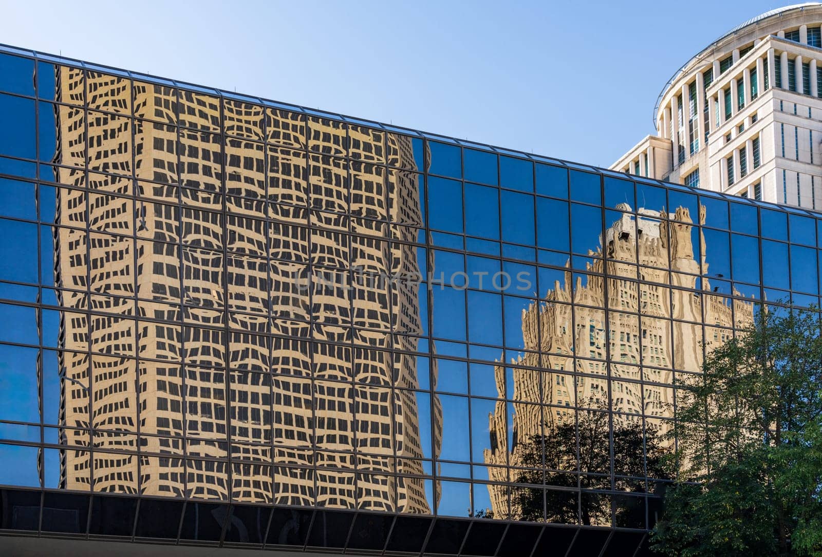 Reflections of two modern office skyscrapers in a mirrored building on Market street in downtown St Louis in Missouri