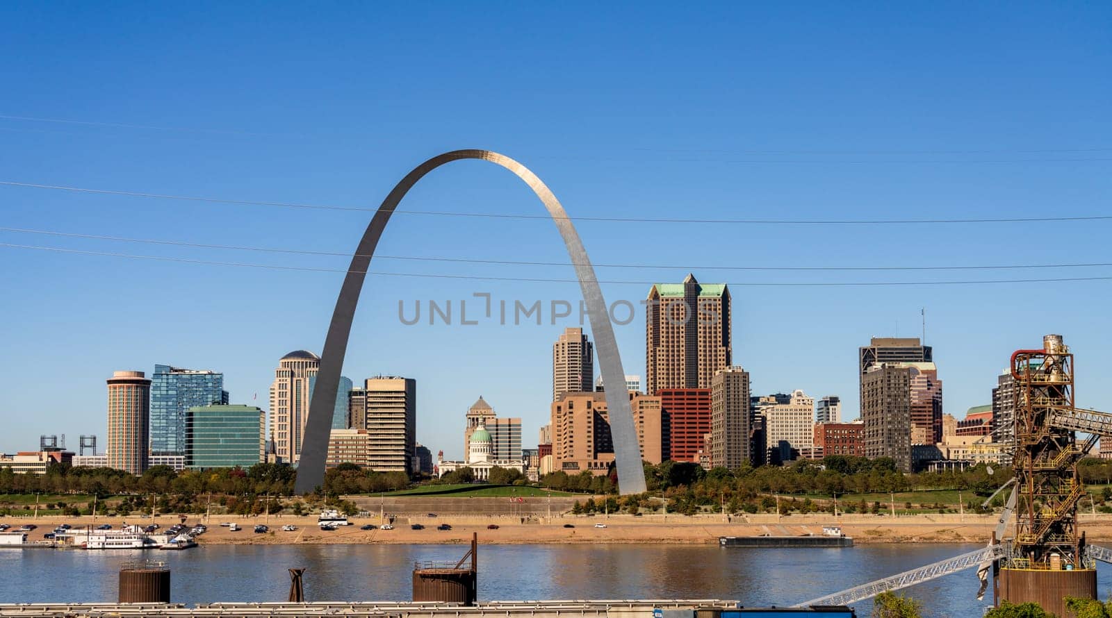Low water levels in Mississippi river give unusual view of the Gateway arch towering over the riverbank from overlook in Illinois