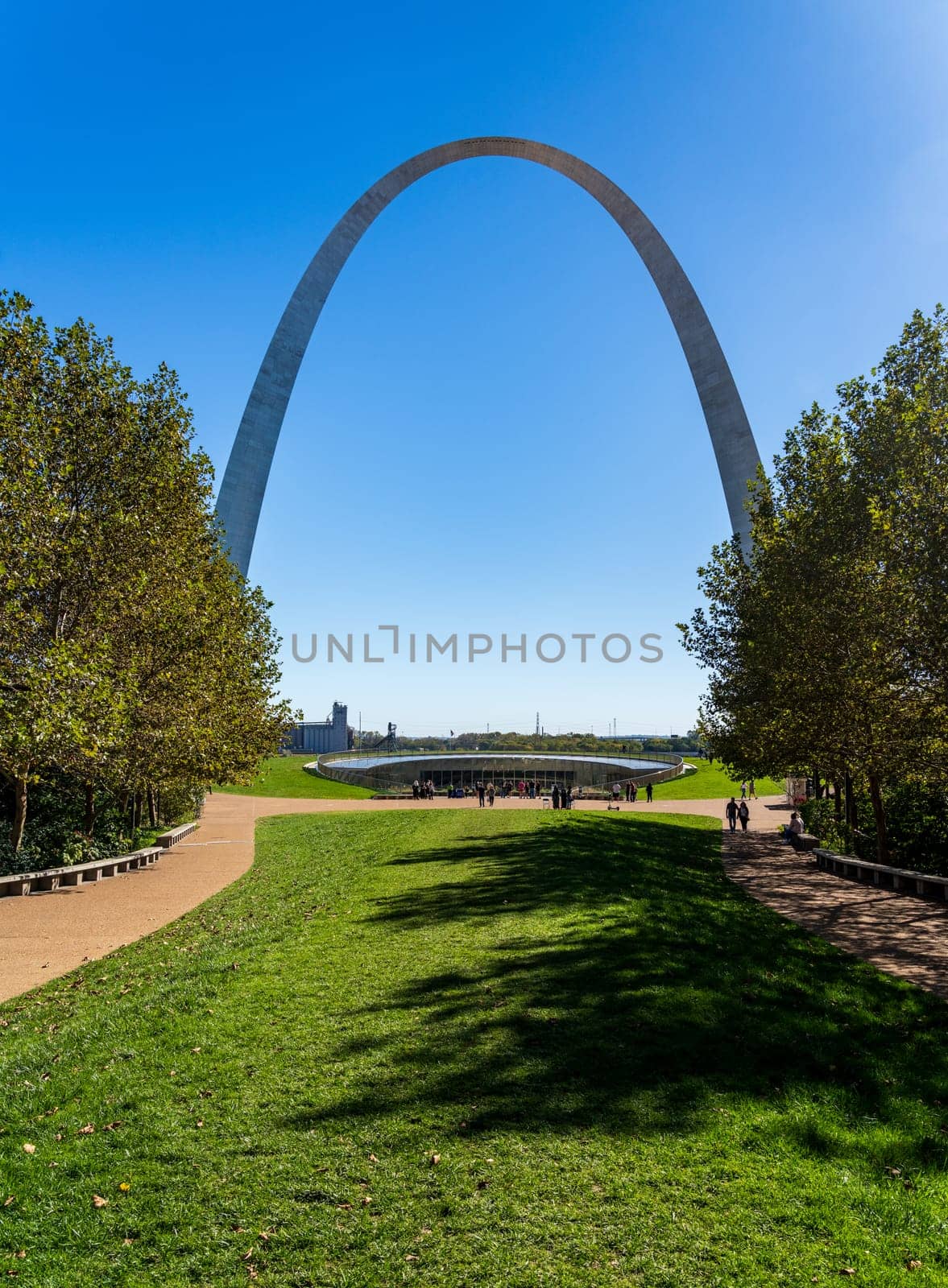 View across green planting of National Park to Gateway Arch and trail in downtown St Louis Missouri