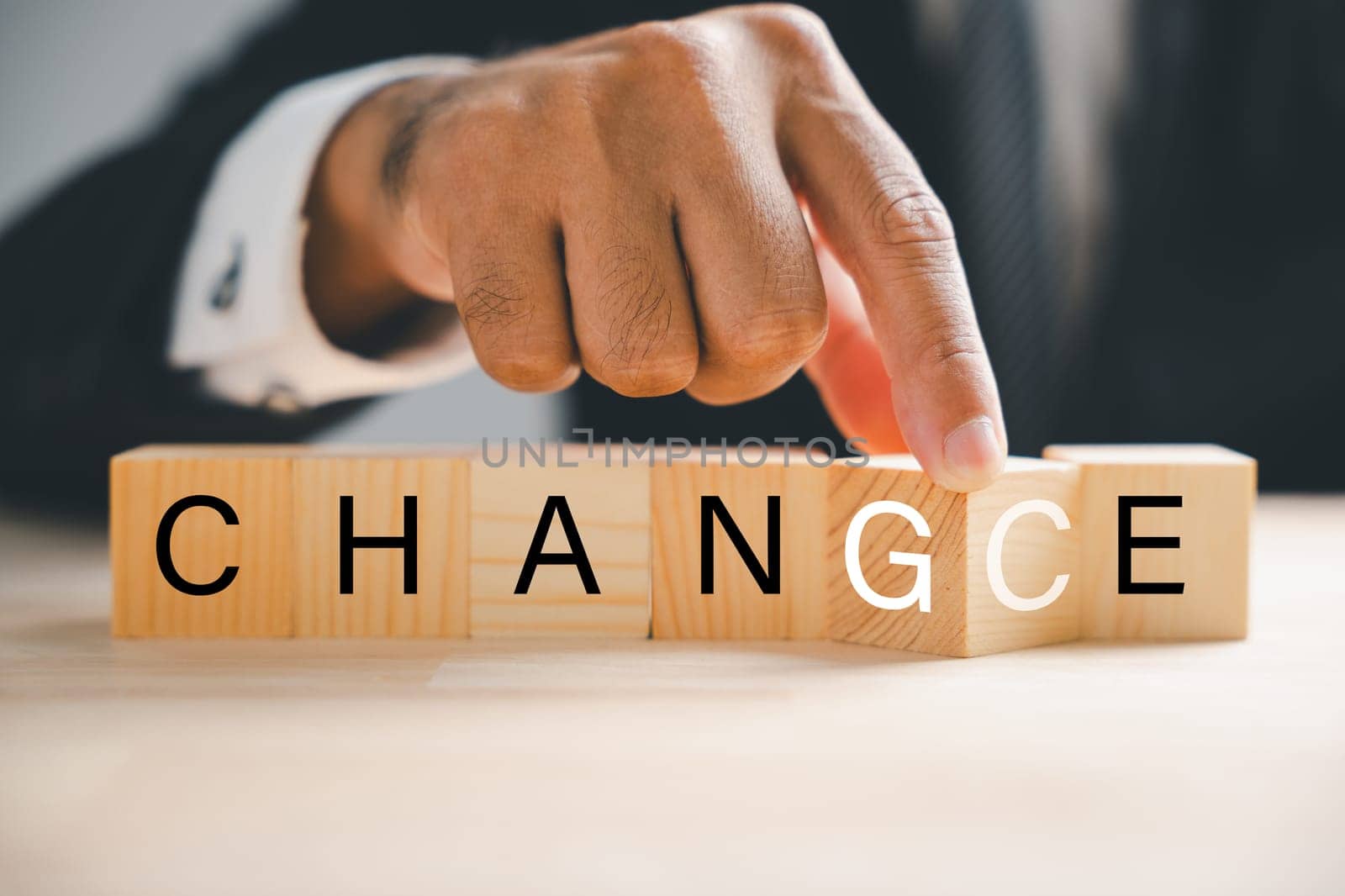 Businessman hand holds wood cube, changing CHANGE to CHANCE. Success, strategy, and positive thinking concepts embodied. Table texture adds depth. Change is.