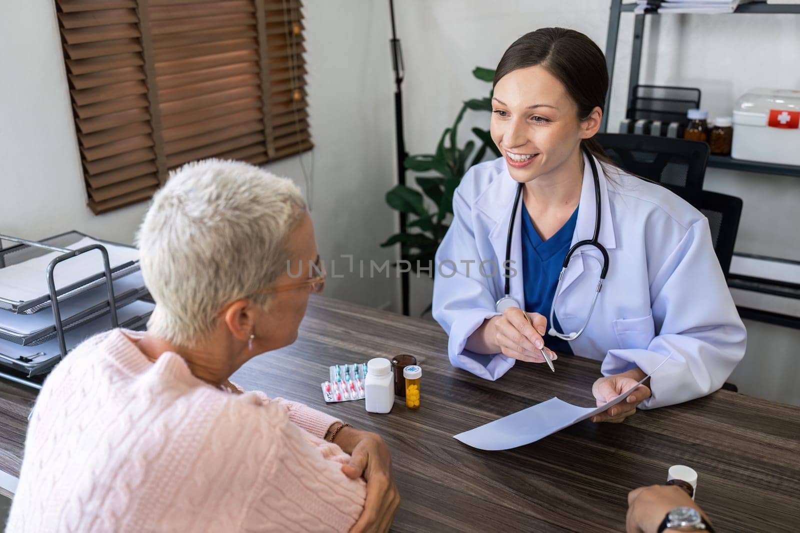 Caucasian Female doctor are advice medication and vitamin daily to caucasian elderly patient.