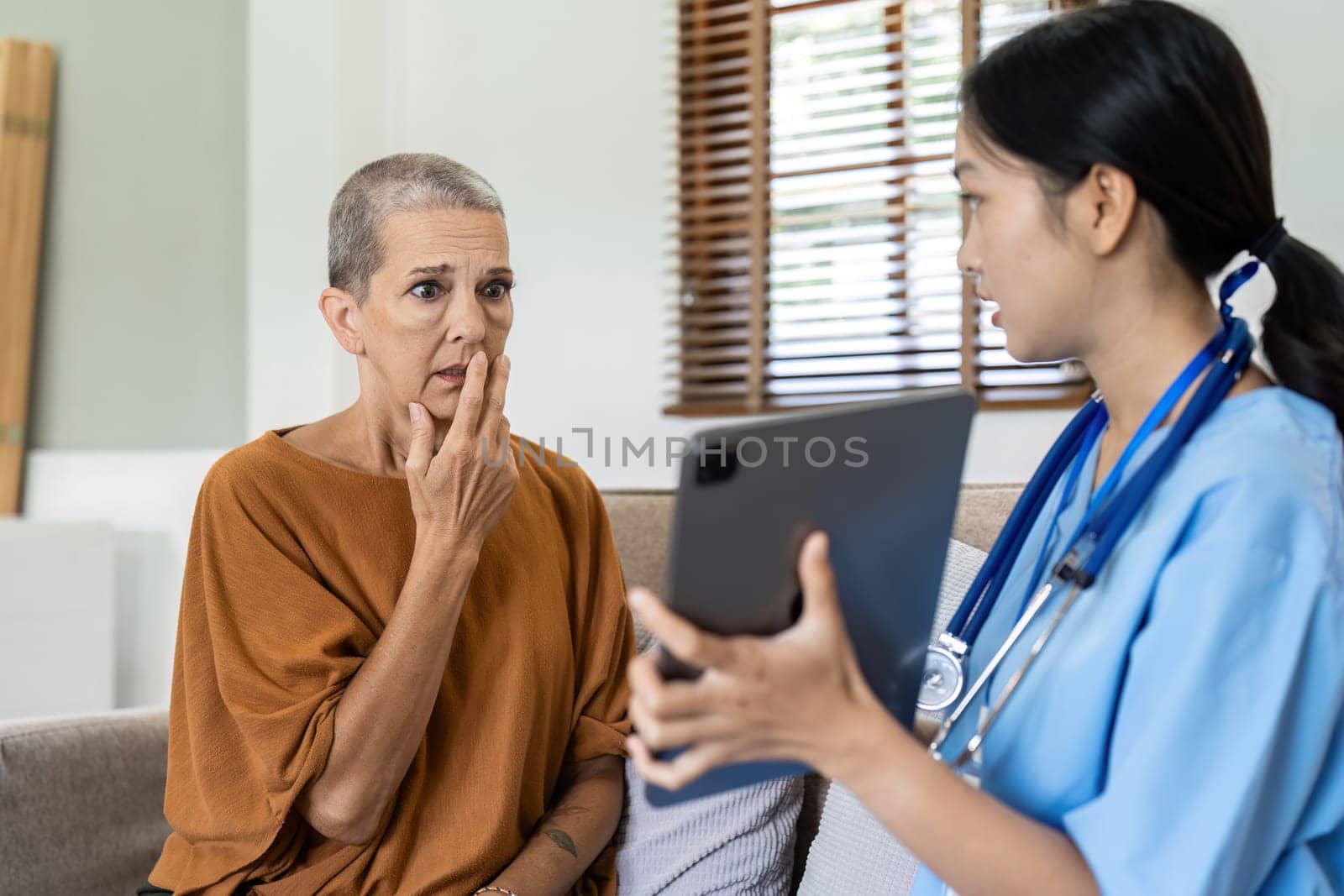Asian nurse showing health checkup report to older and giving advice. Home nursing and healthcare caregiver concept by itchaznong