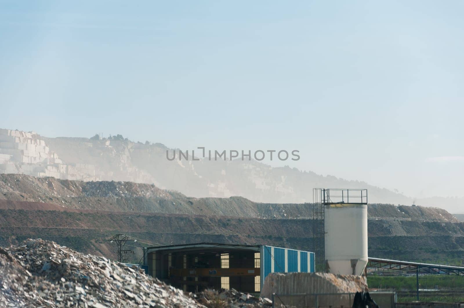 view of an open pit marble quarry showing heavy duty equipment and rock. High quality photo