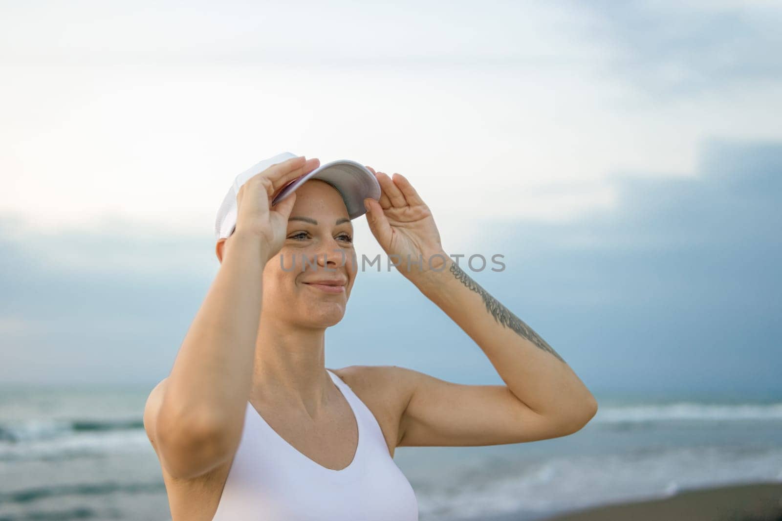 a portrait of a fair-looking girl in a white top and top stands against the backdrop of the sea, there is a place for an inscription. High quality photo