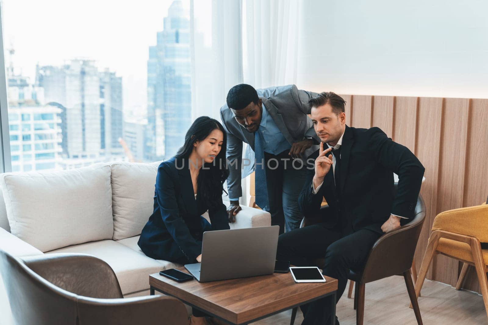 Diverse business team looking at laptop while discussing about business idea. Group of happy manager talking , thinking sharing business strategy while young businesswoman using laptop. Ornamented.