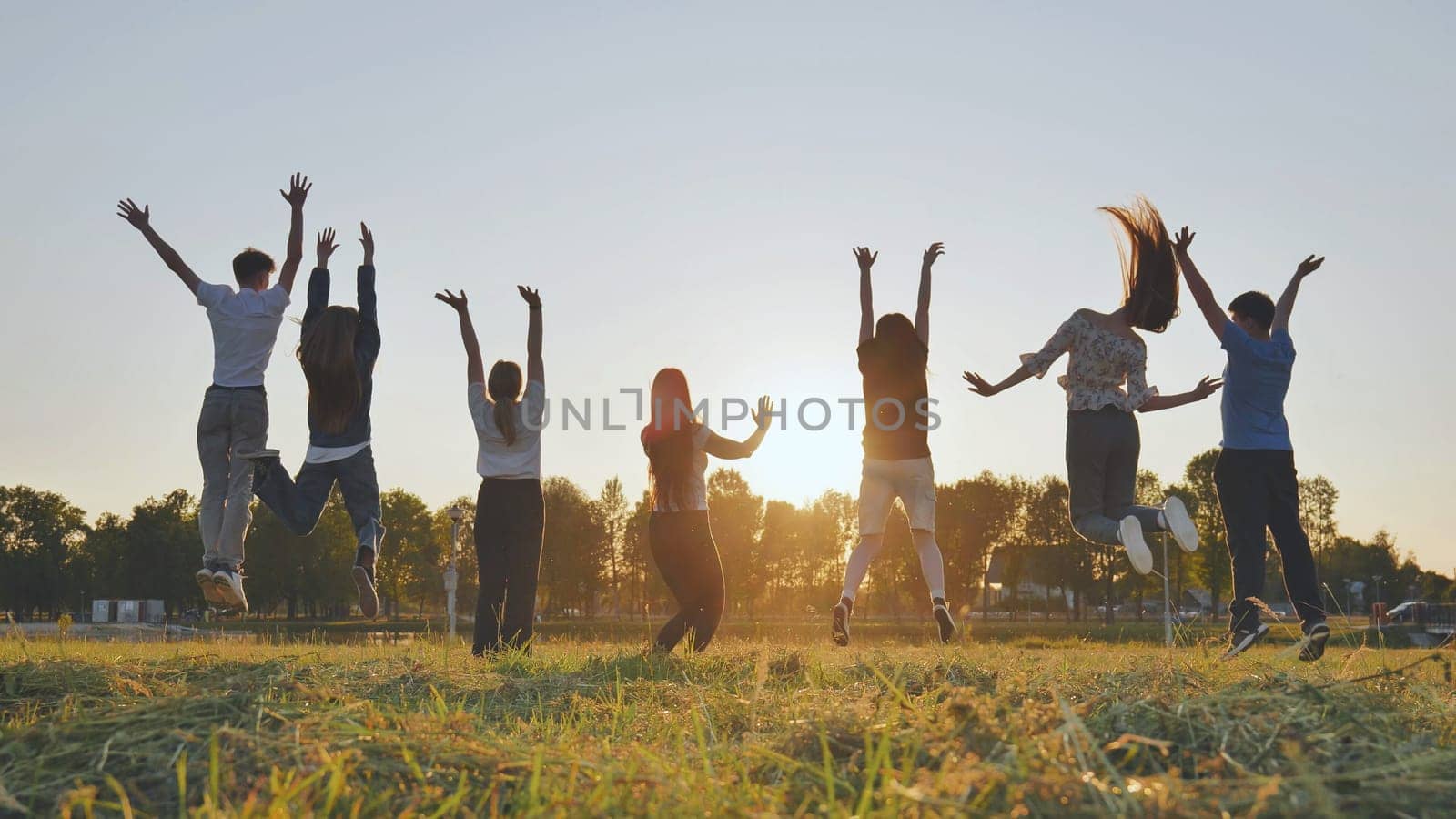 Merry friends jumping around at sunset. by DovidPro