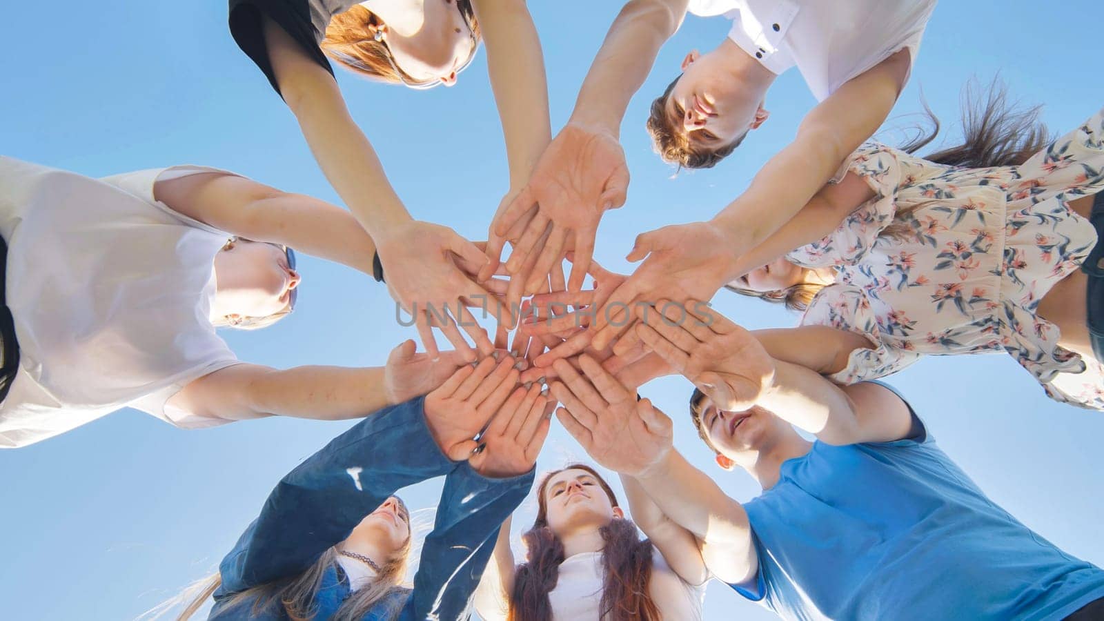 Friends putting their hands together in a sign of unity and teamwork. Just the hands. by DovidPro