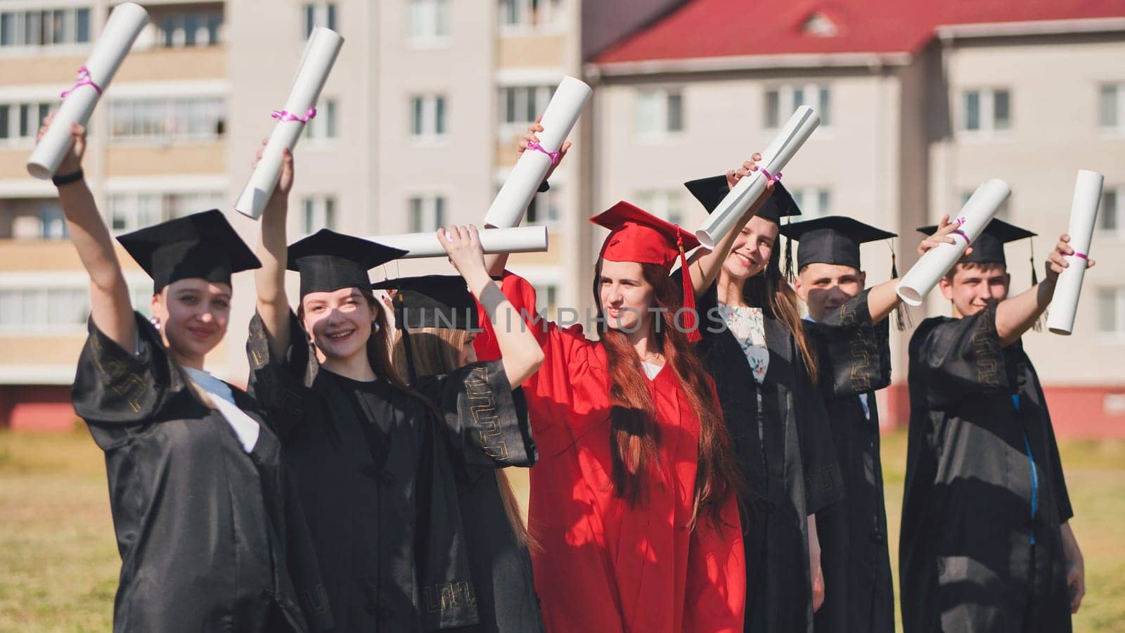 group of multiracial graduates holding diploma. by DovidPro