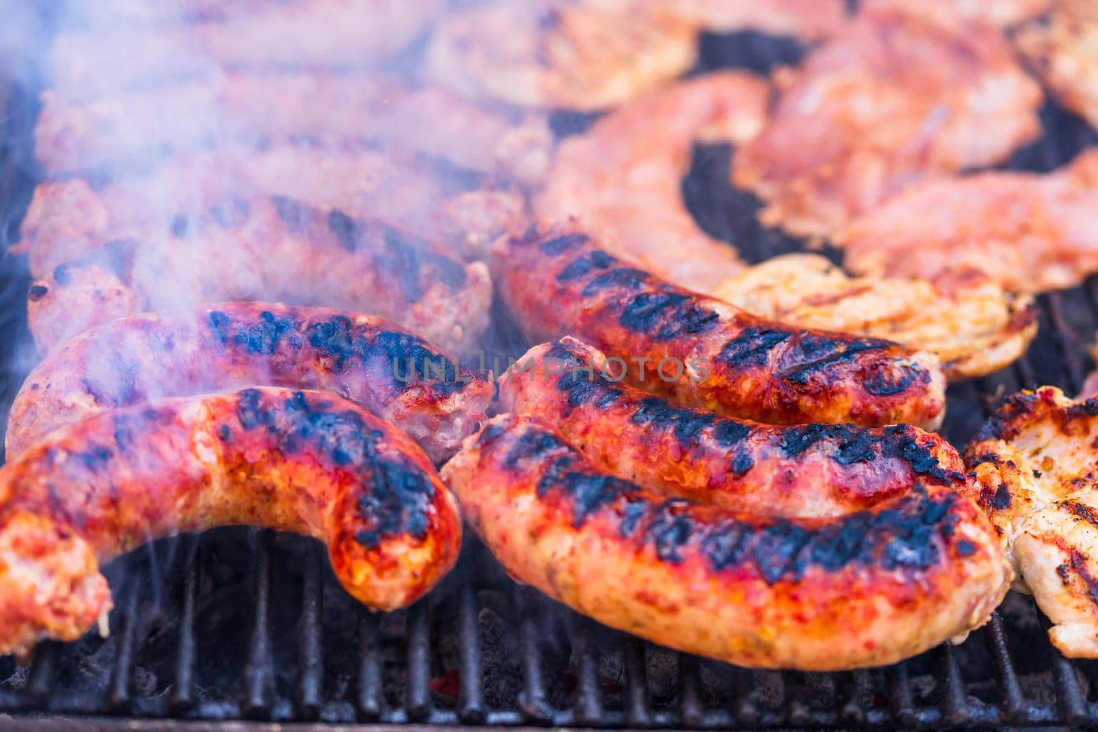 Pork meat and sausages grilled on a charcoal barbeque. Top view of tasty barbecue, food concept, food on grill and detail of food on the grill