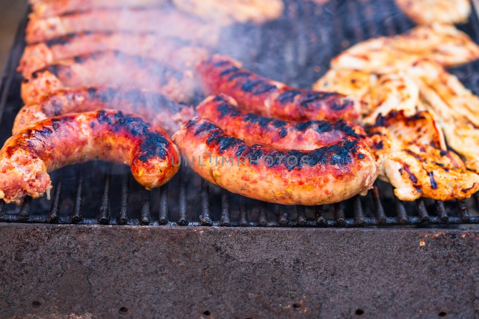 Grilling sausages and pork chops on barbecue grill. BBQ in the garden