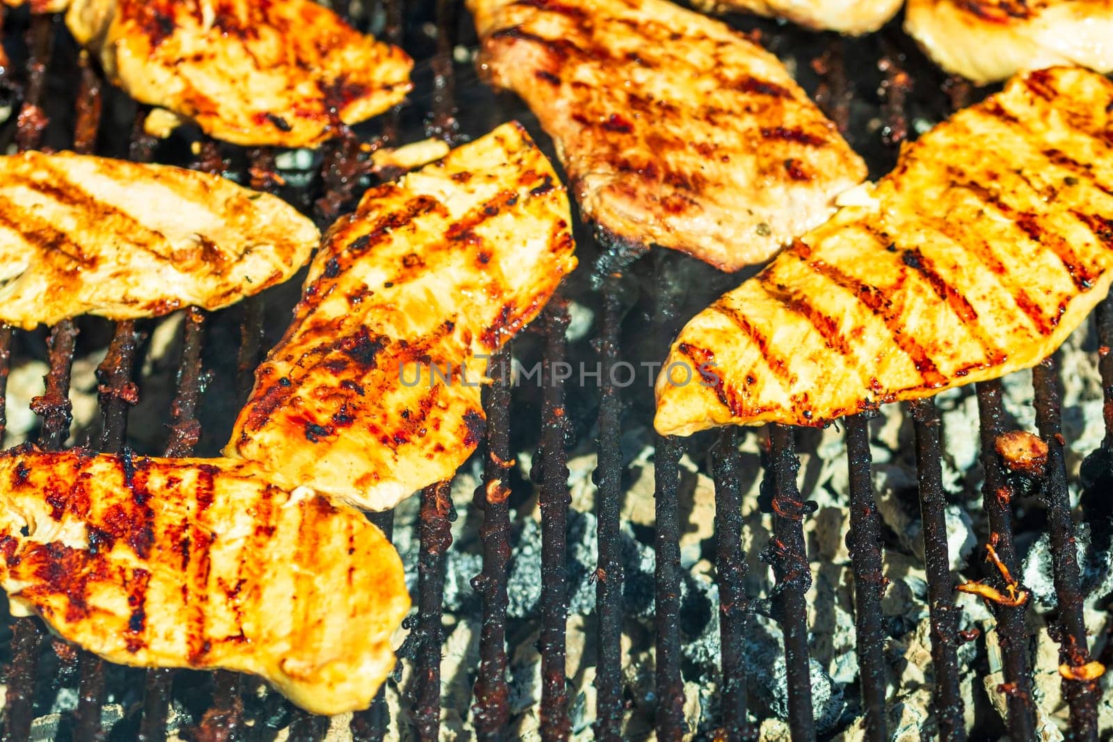 Chicken and pork steak grilled on a charcoal barbeque. Top view of camping tasty barbecue, food concept, food on grill and detail of food on the grill