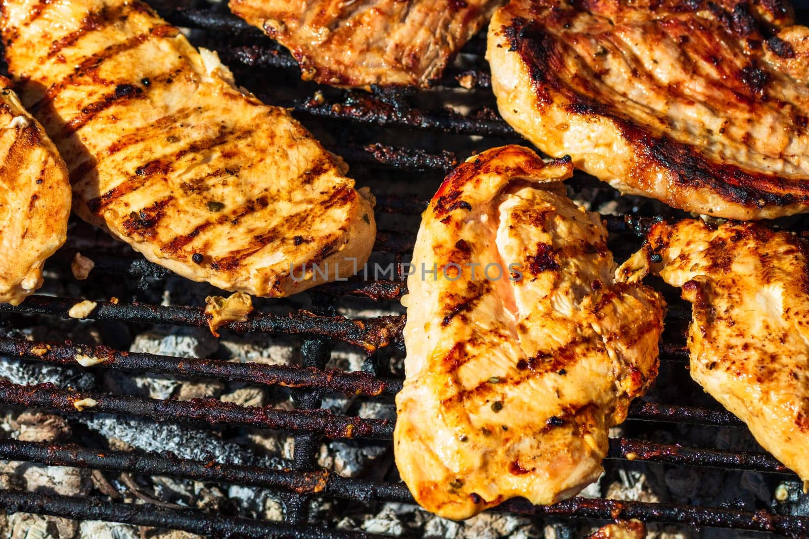 Chicken and pork steak grilled on a charcoal barbeque. Top view of camping tasty barbecue, food concept, food on grill and detail of food on the grill