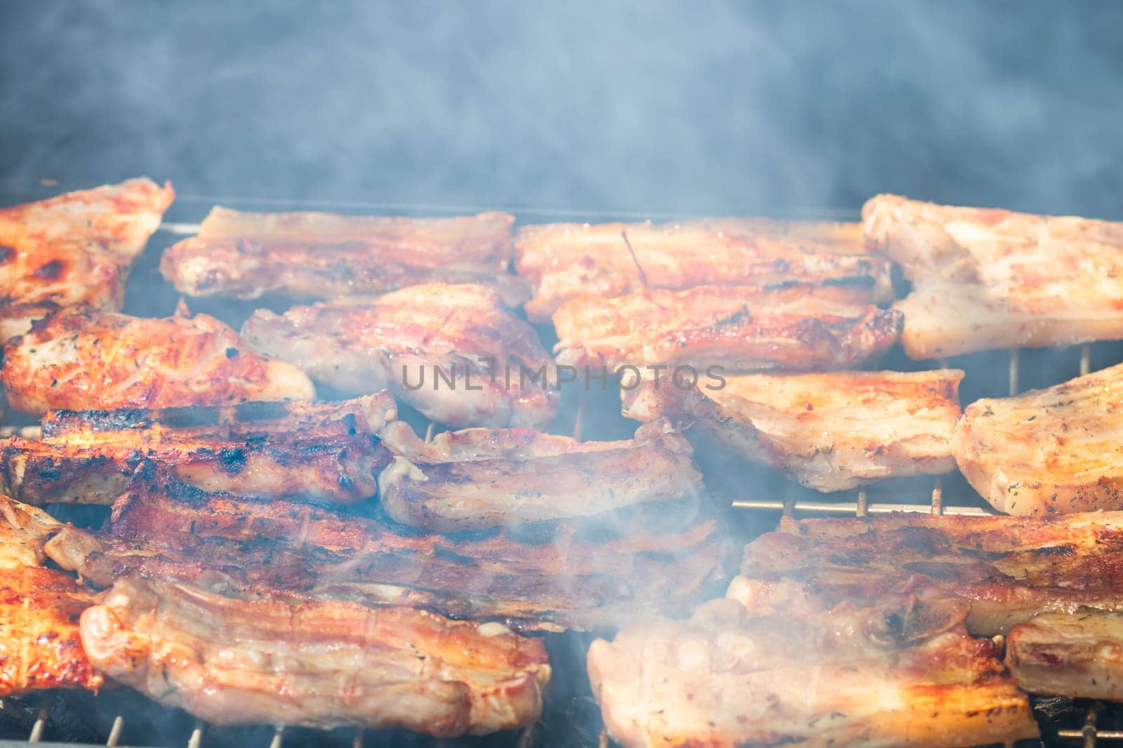 Assorted delicious tasty grilled meat with vegetables being cooked on charcoal grill