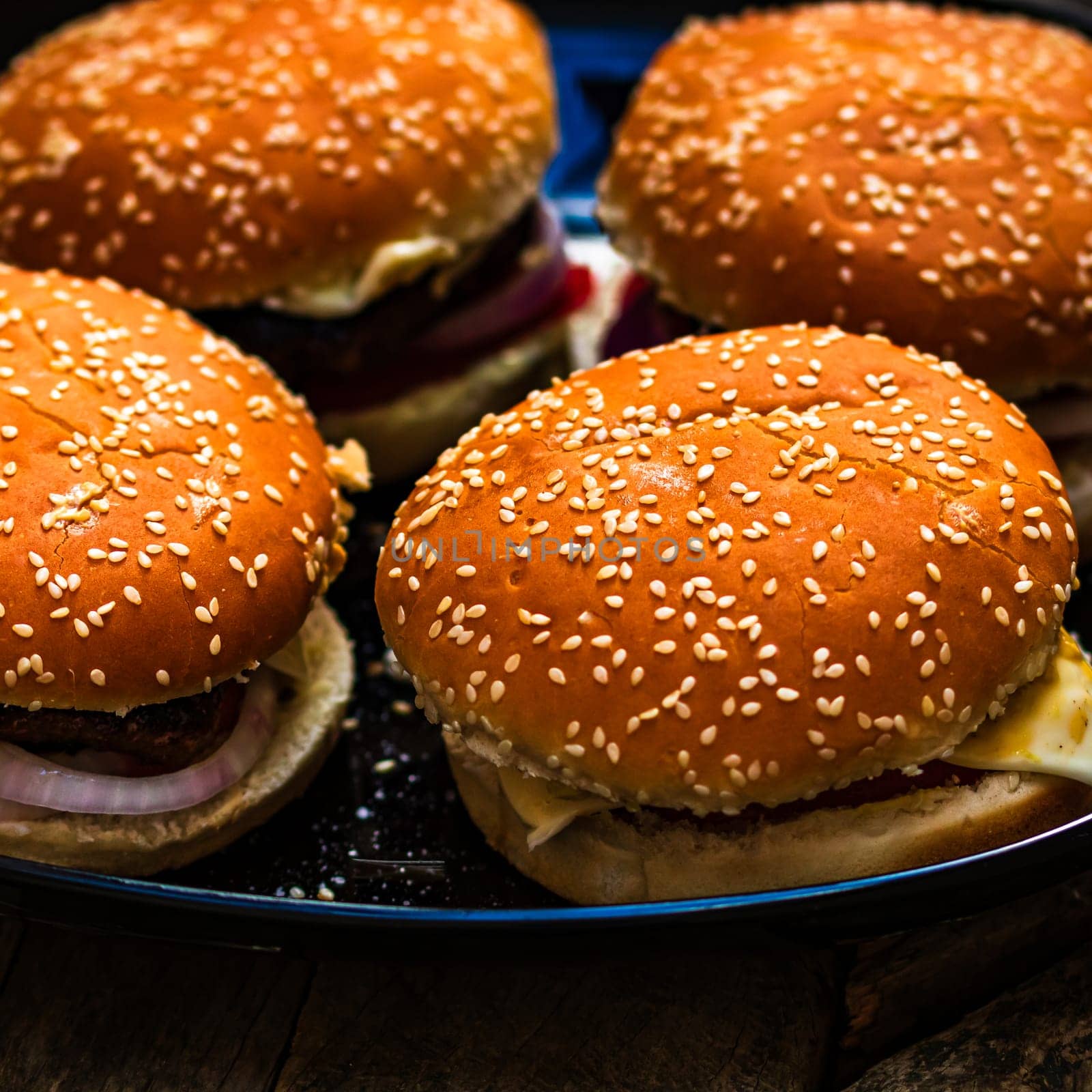 Tasty home made cheeseburger. Cheese burger with pickles, tomatoes, onion, melting cheese